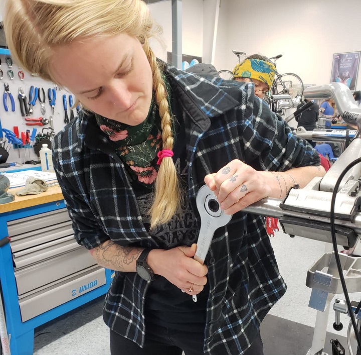 Kate Sage works on getting a fixed cup out of our "funny bike" on a serviceable cup'n'cone bottom bracket.